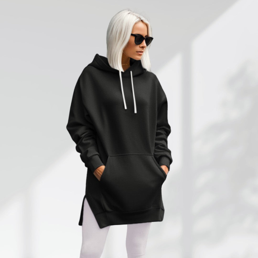 Woman wearing a black hoodie dress, standing and facing forward to show the fit and style.