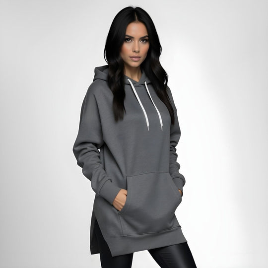 Woman wearing a dark gray hoodie dress, standing and facing forward to show the fit and style.